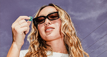 Woman wearing sunglasses with a purple sky background